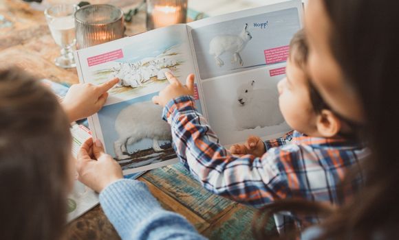 Mutter liest gemeinsam mit Sohn und Tochter