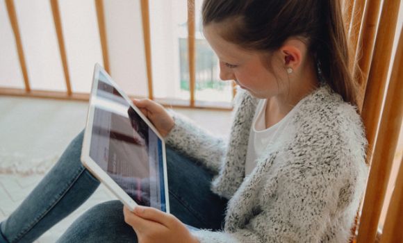 Mädchen schaut auf Tablet