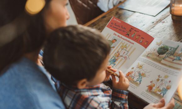 Muter und Sohn lesen gemeinsam eine Weihnachtsgeschichte