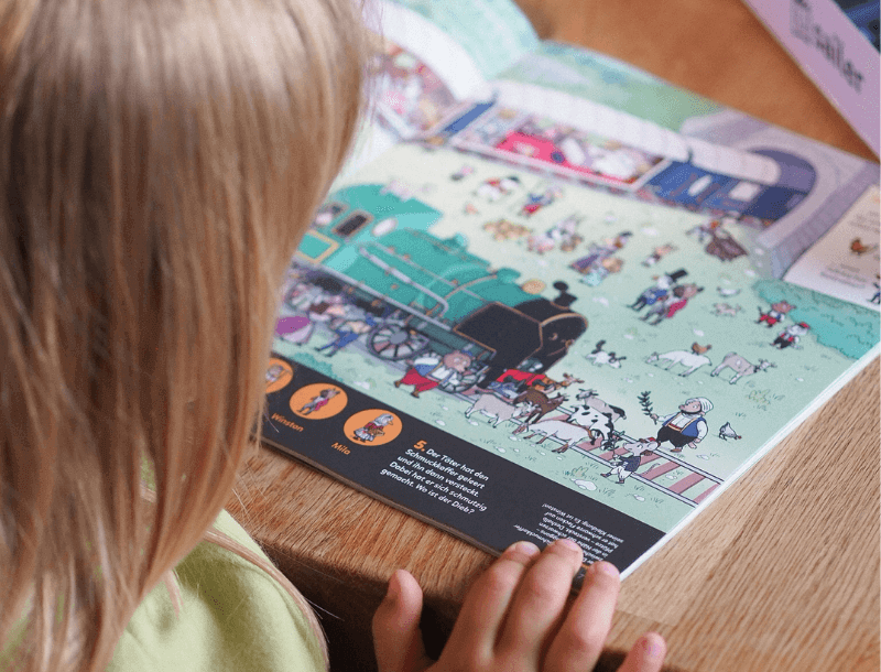 Blog_Headerbild_Wertvolle_Geschenkideen Ein Kind liest in einer pädagogisch wertvollen Zeitschrift.