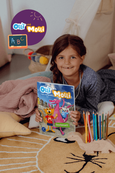 Ein lächelndes Kind sitzt auf einem Teppich und hält ein Magazin mit dem Titel 'Olli und Molli'. Im Hintergrund liegt ein Zelt und um das Kind herum liegen bunte Buntstifte in einem Dinosaurier-Stifthalter. Oben links im Bild ist das Logo von 'Olli und Molli' und eine kleine Tafel mit 'ABC' zu sehen.